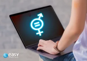 Imagem de uma pessoa com um notebook no colo mostrado na tela um símbolo unificado de igualdade sexual