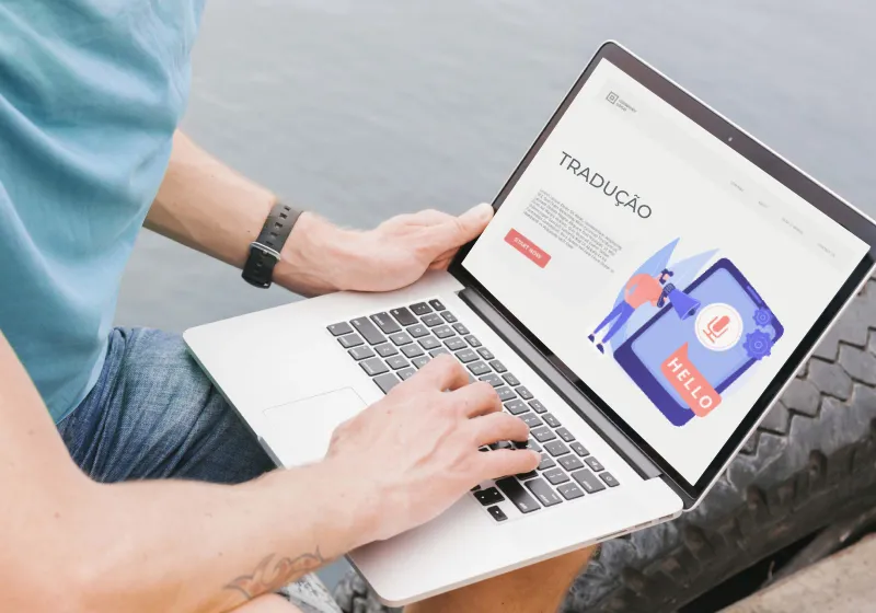 Imagem de pessoa branca com roupa azul usando notebook pesquisando sobre tradutor acadêmico.