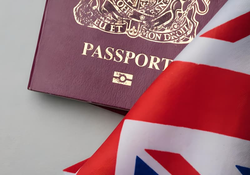 Passaporte ao lado de uma bandeira do Reino Unido