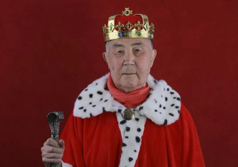 homem vestido de rei em um fundo vermelho