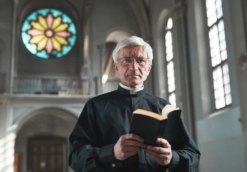 imagem de um padre com uma bíblia na mão em uma igreja em um fundo fosco 