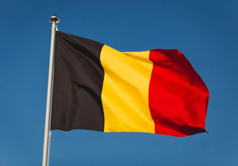 imagem de uma bandeira de Bélgica em um céu azul 