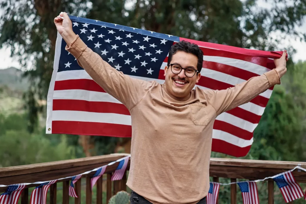 Homem feliz com a bandeira dos Estados Unidos, pois está contando com um tradutor de inglês americano para ajudá-lo