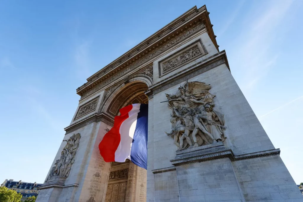 O Arco do Triunfo decorado com a bandeira da França para representar a tradução juramentada em francês