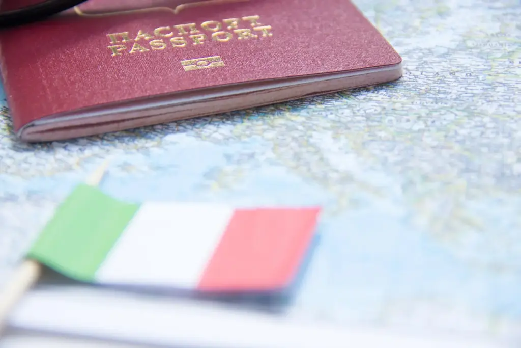Passaporte sobre mapa e bandeira da Itália, simbolizando cidadania italiana por descendência