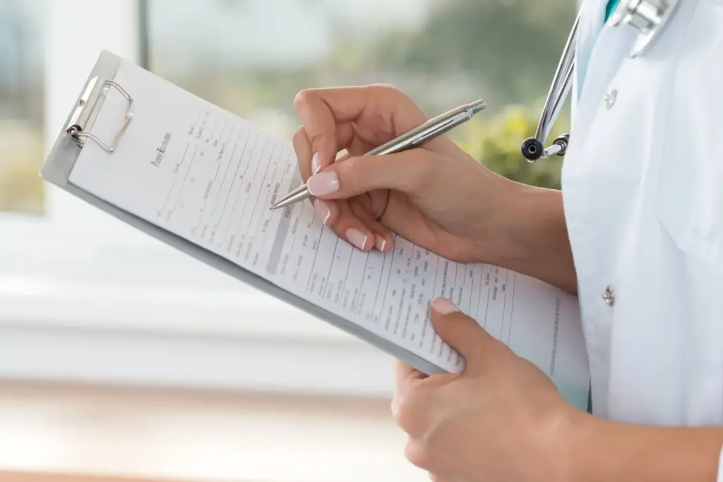 Médico preenchendo formulário em prancheta, ilustrando a tradução juramentada de prontuários médicos