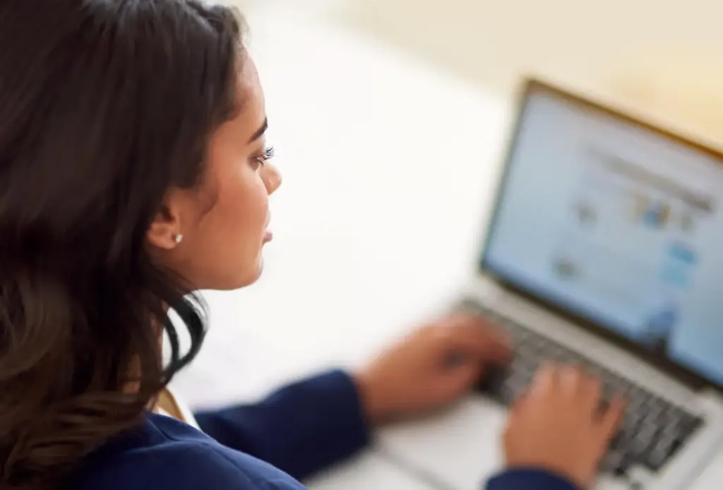 Mulher usando notebook para pesquisar tradução juramentada perto de mim