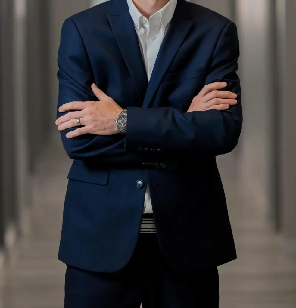 Homem vestido de terno com braços cruzados, representando os serviços de tradução para empresas