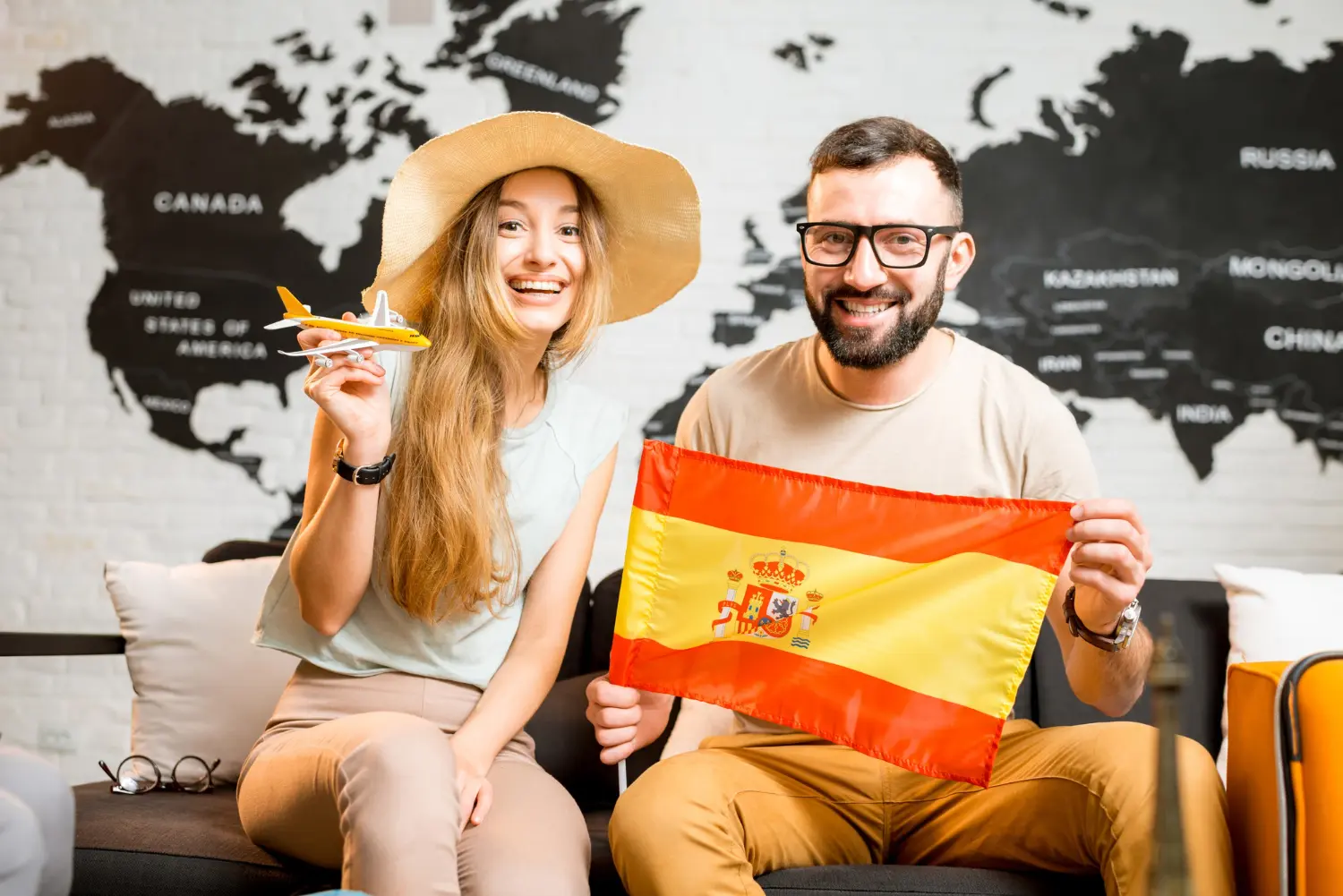 duas pessoas sorrindo e segurando a bandeira da Espanha